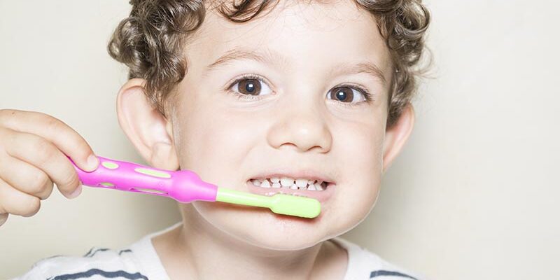 Niño y cepillo de dientes